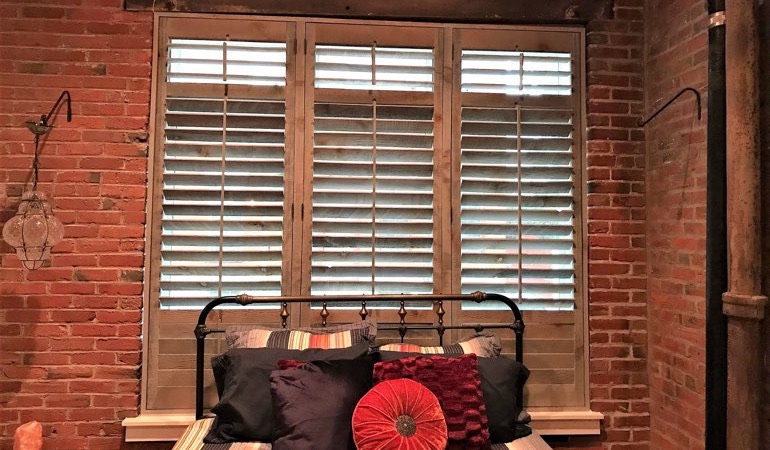 Reclaimed wood shutters near a brick wall.